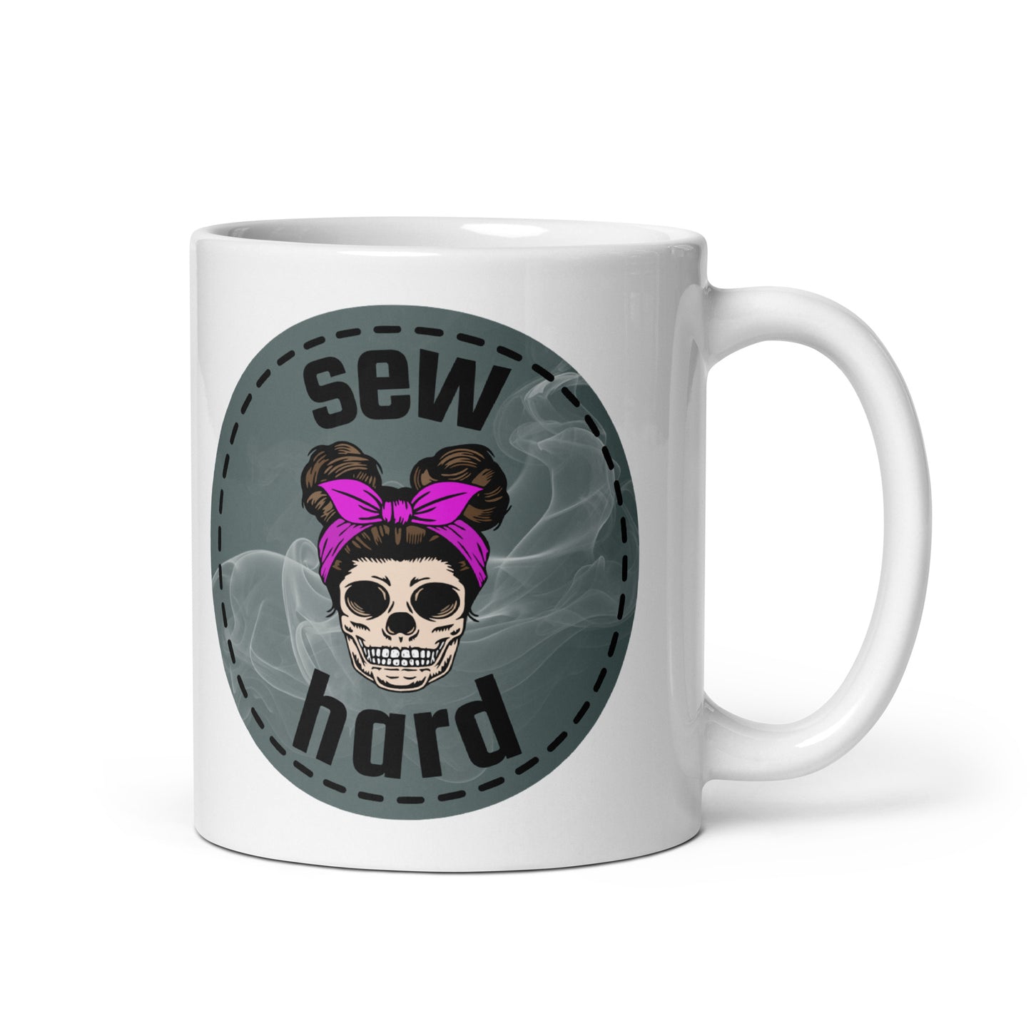 White ceramic mug with Sew Hard skull design featuring pigtail buns, pink bow, and smoky sage green background – sewing gift for quilters and sewists