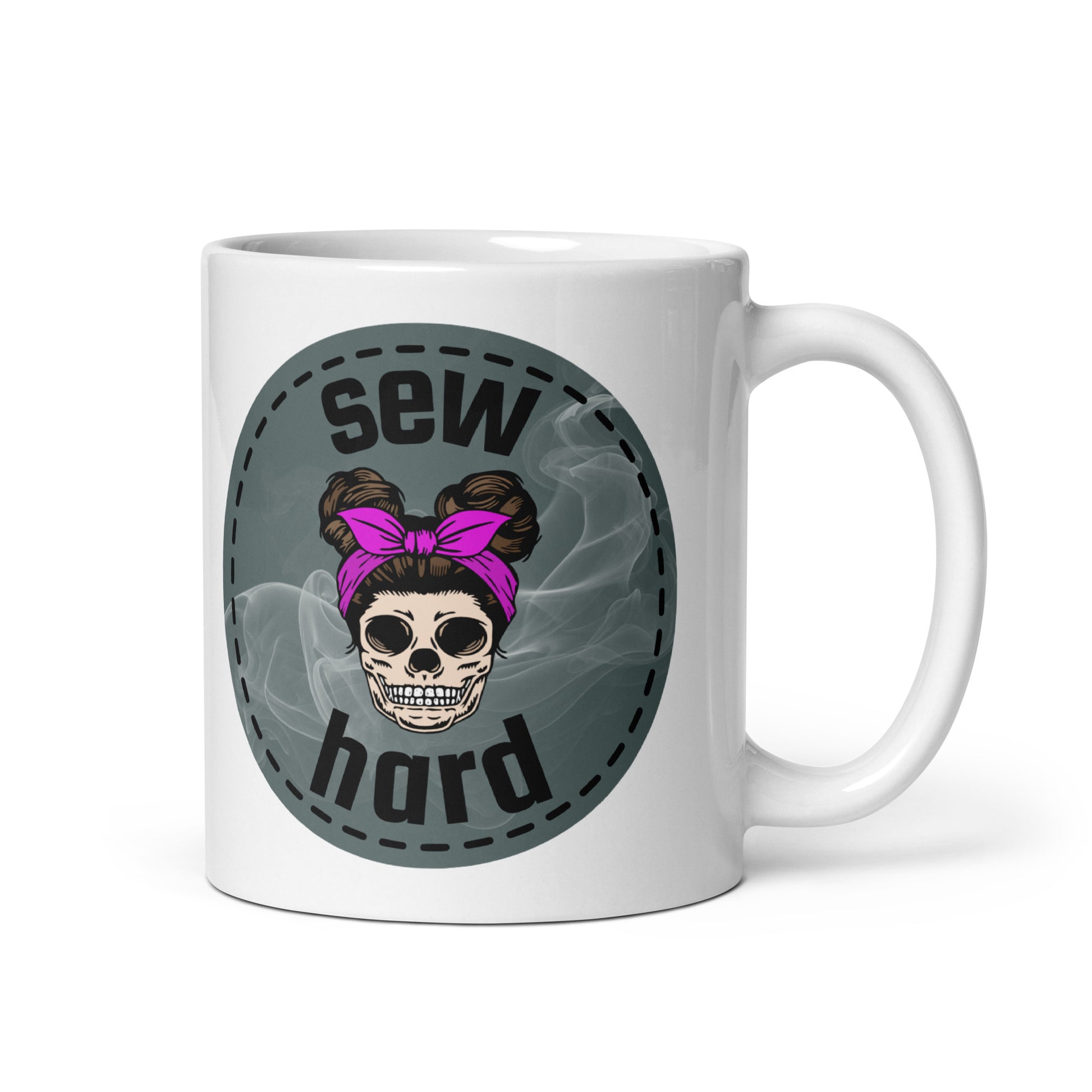 White ceramic mug with Sew Hard skull design featuring pigtail buns, pink bow, and smoky sage green background – sewing gift for quilters and sewists
